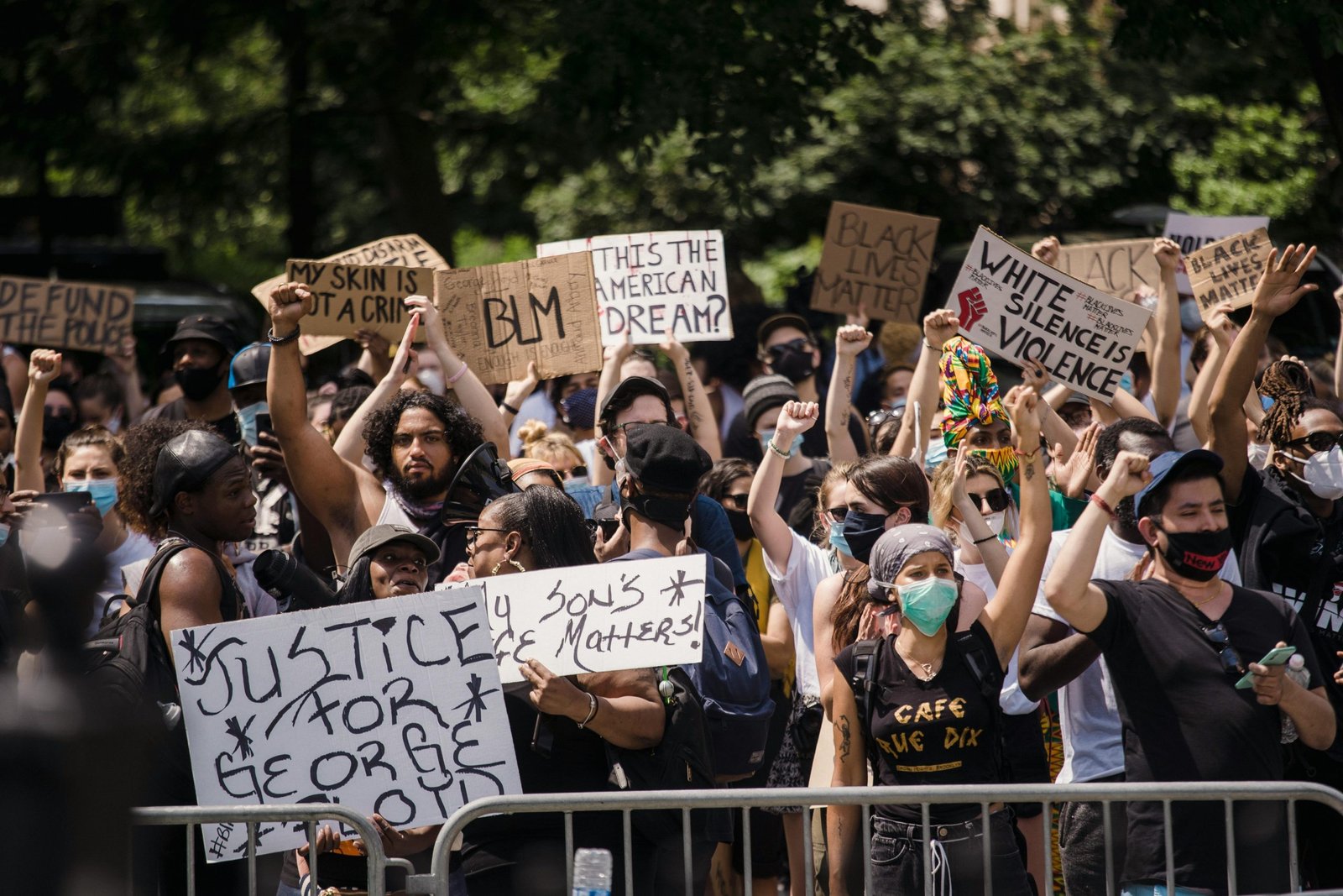 Protesters rally for justice and equality, displaying powerful signs in a city street.